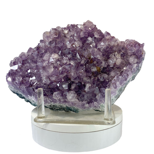 Rich amethyst cluster from South America with cacoxenite inclusions on white background