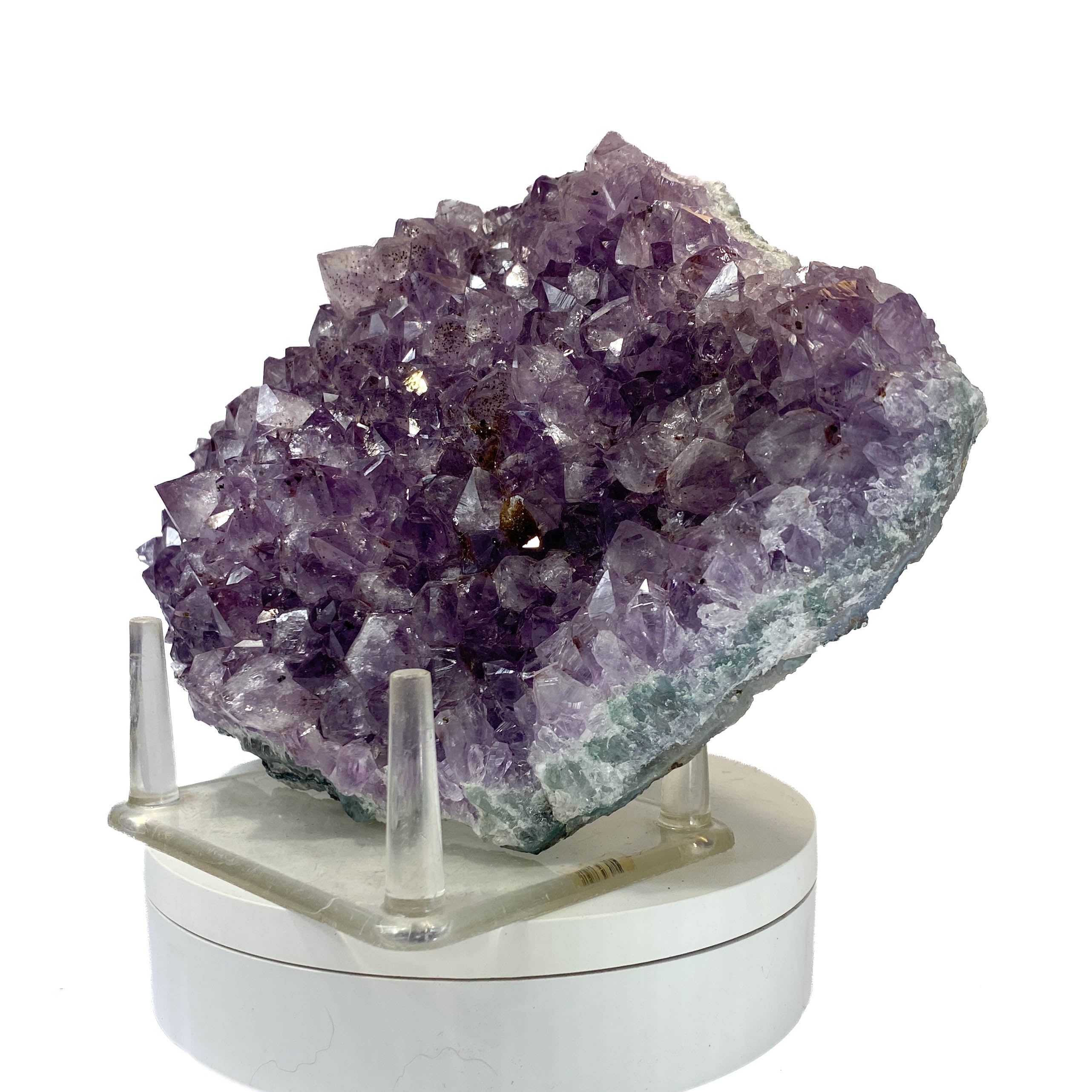 Rich amethyst cluster from South America with cacoxenite inclusions on white background