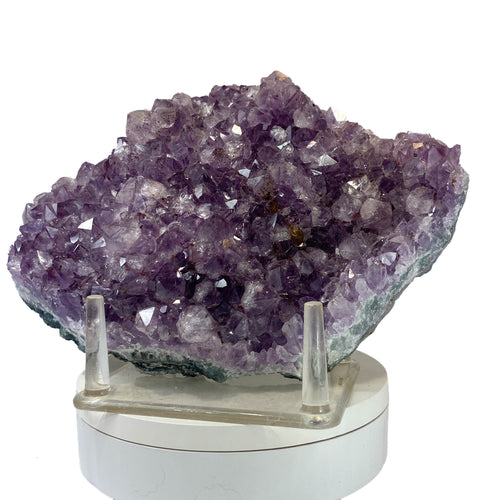 Rich amethyst cluster from South America with cacoxenite inclusions on white background