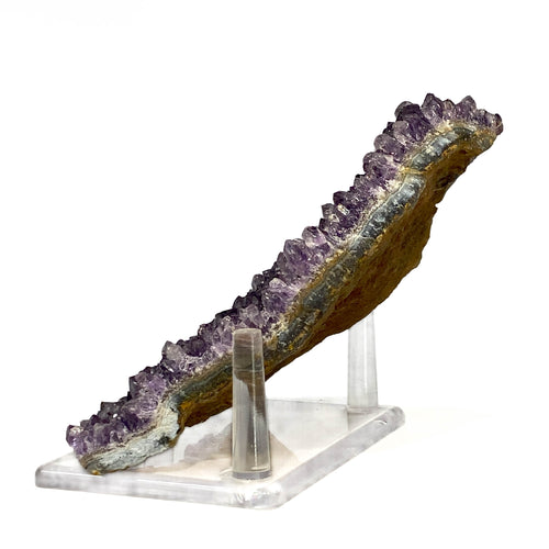 Dark purple amethyst cluster with fine crystal points on white background