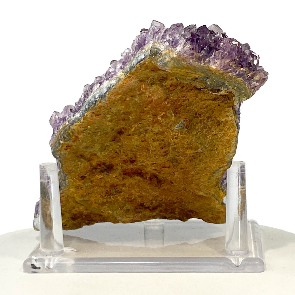 Dark purple amethyst cluster with fine crystal points on white background