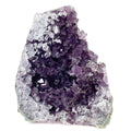 Dark purple amethyst cluster with cross-cut crystal faces on white background