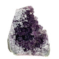 Dark purple amethyst cluster with cross-cut crystal faces on white background