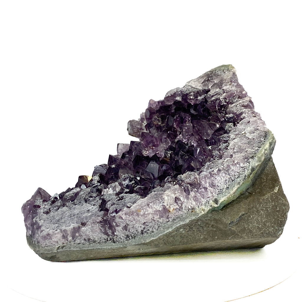Dark purple amethyst cluster with cross-cut crystal faces on white background