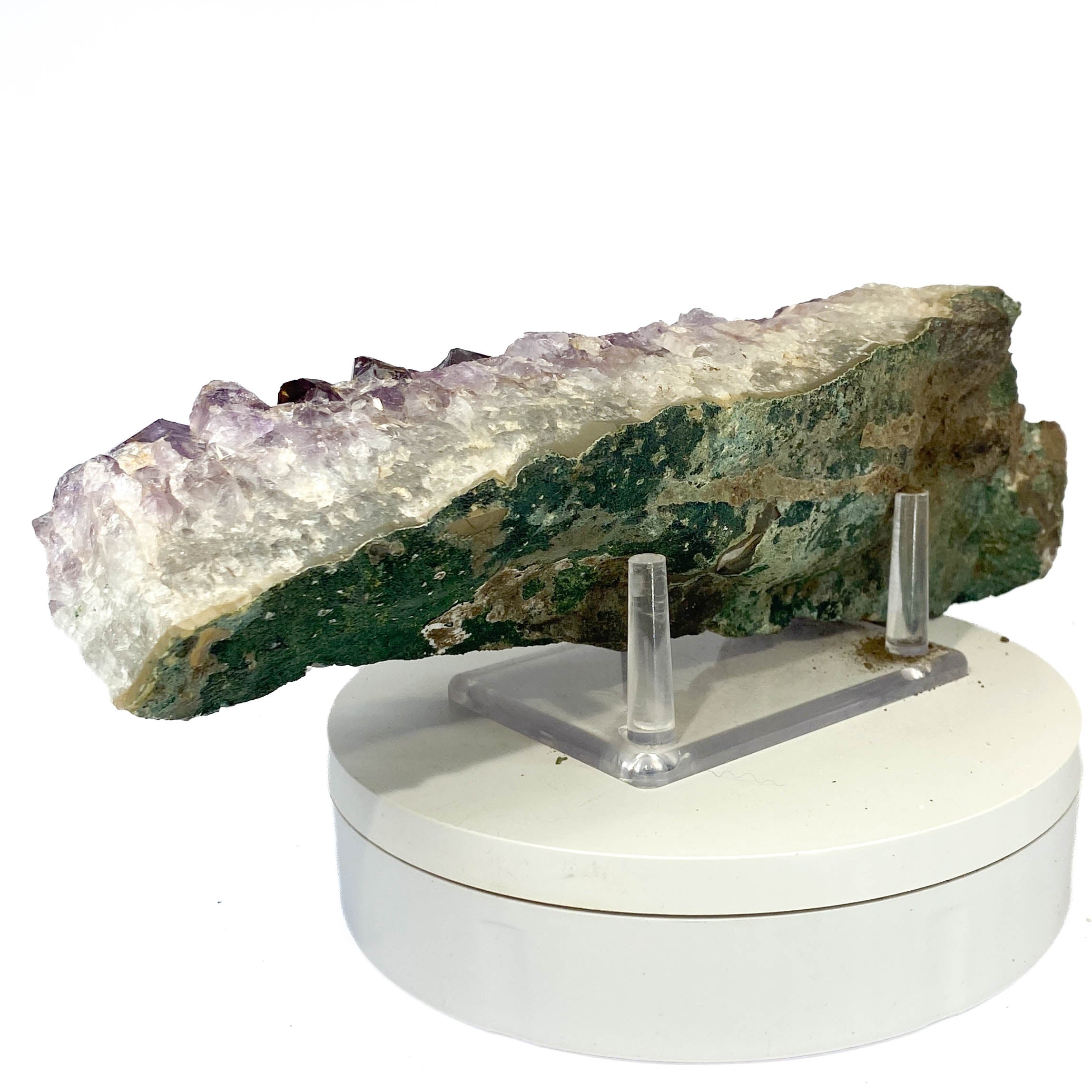 Elongated amethyst cluster with clear, iron-included crystals on white background