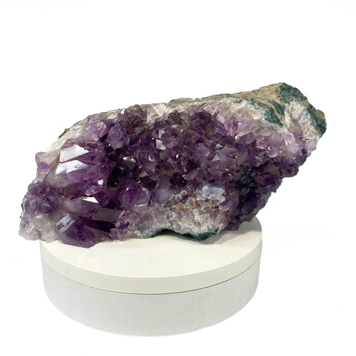 Dark amethyst horizontal standing cluster with small stalactites on white background