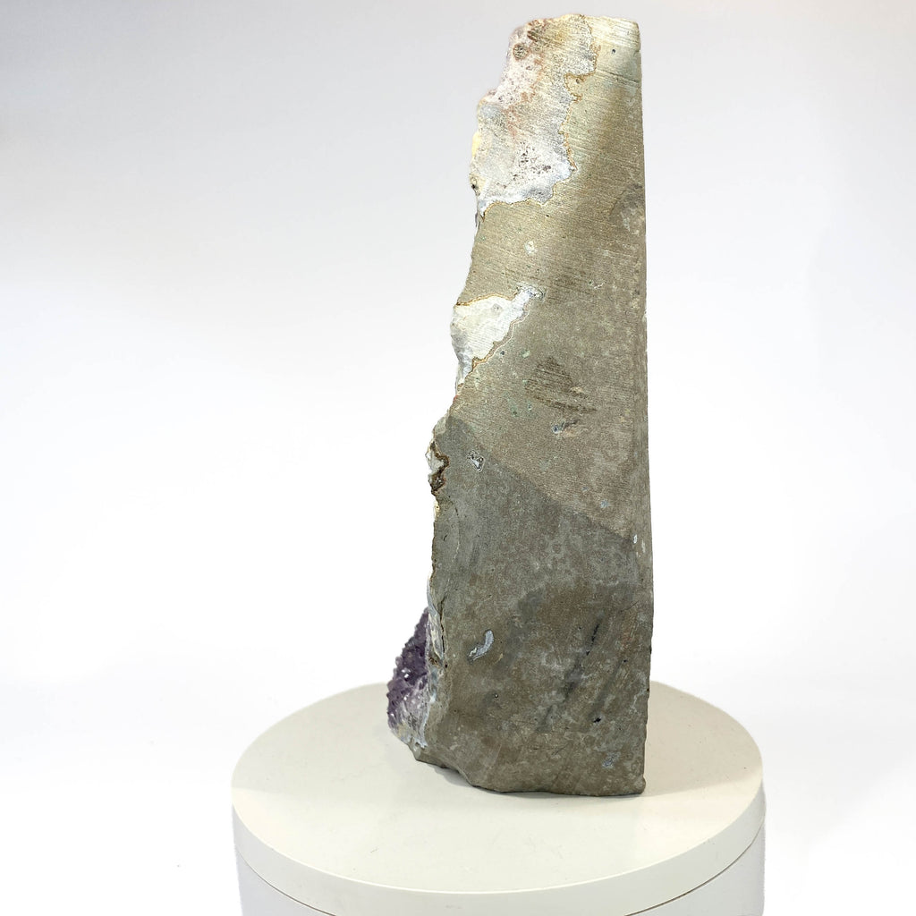 Standing deep amethyst cluster with black nodule inclusions on white background