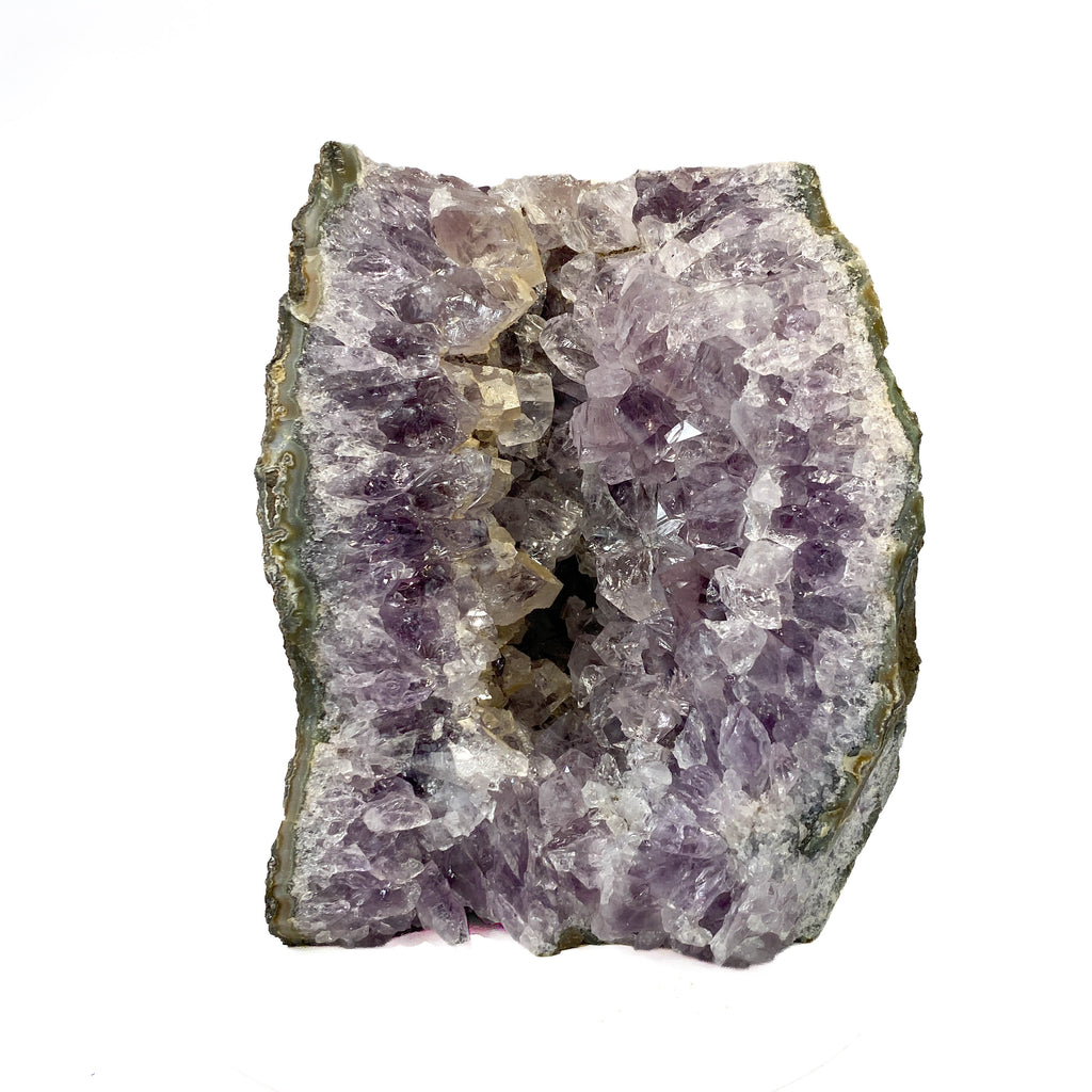 Amethyst geode cross section with clear crystal delineation on white background