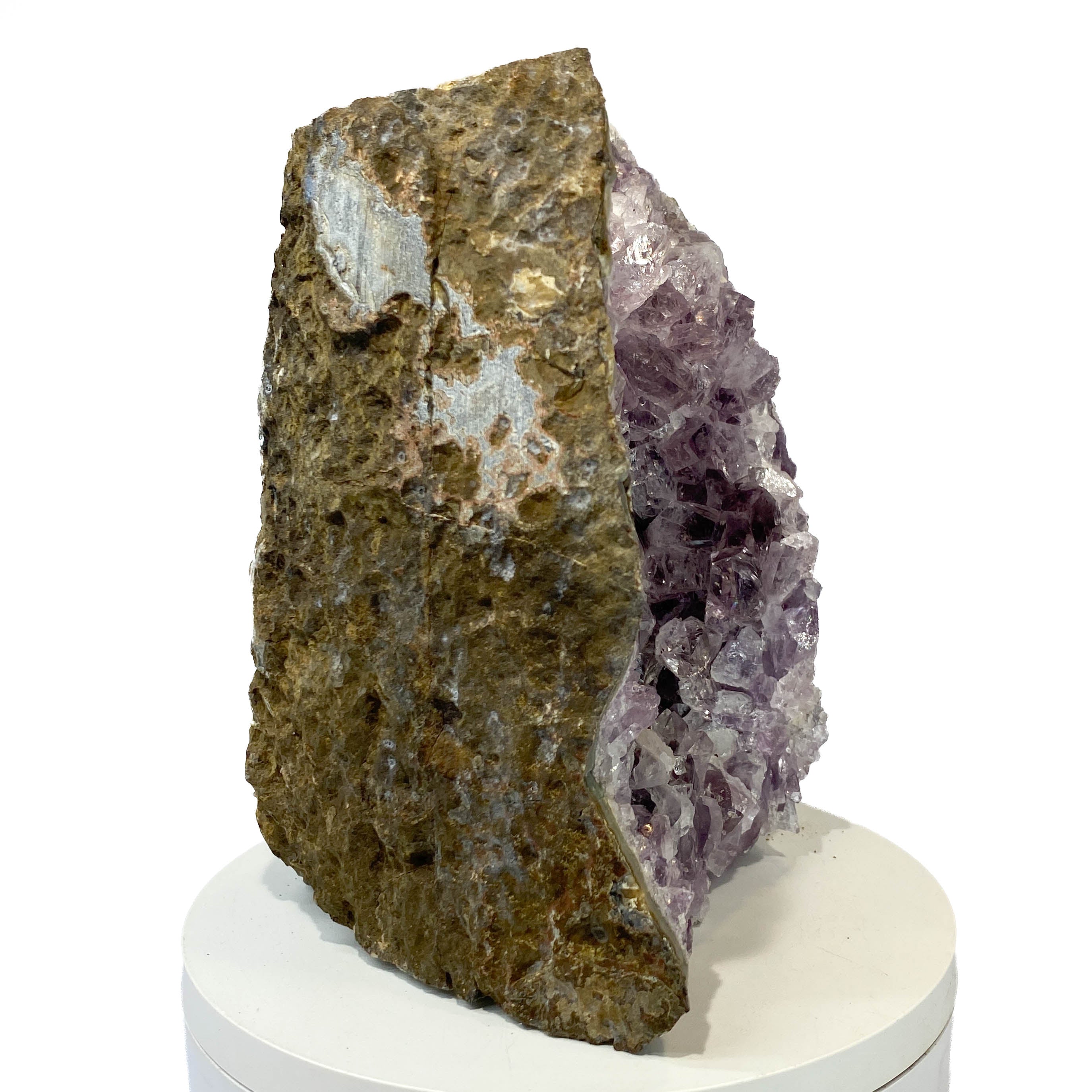 Amethyst geode cross section with clear crystal delineation on white background