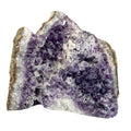 Standing angel-shaped amethyst cluster with dark crystals and phantoms on white background