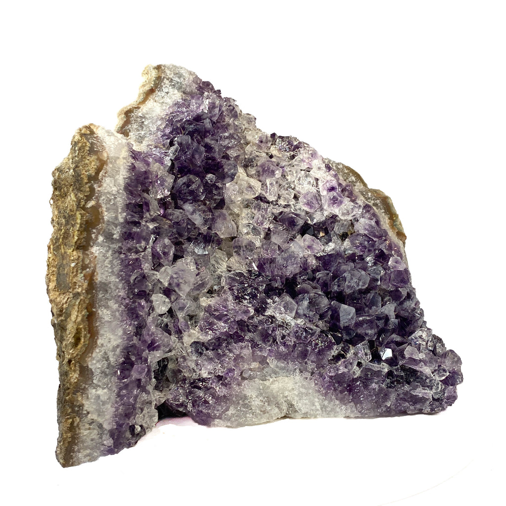 Standing angel-shaped amethyst cluster with dark crystals and phantoms on white background