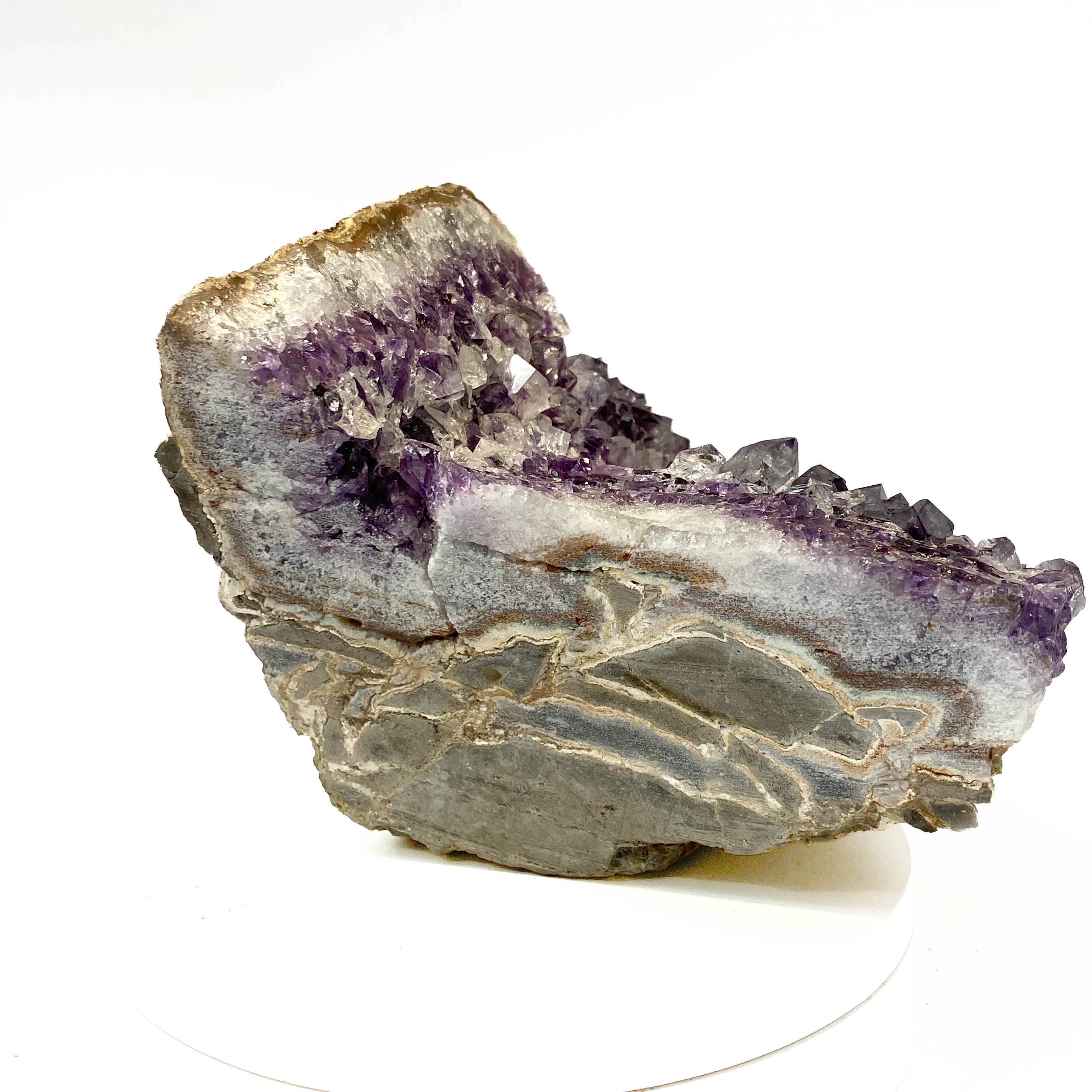 Standing angel-shaped amethyst cluster with dark crystals and phantoms on white background