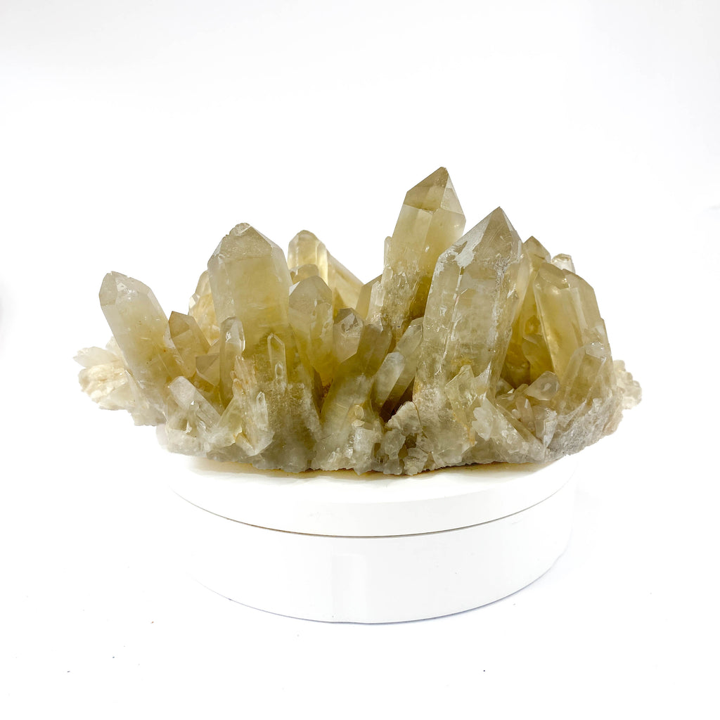 Natural citrine quartz cluster with clear crystal points on white background