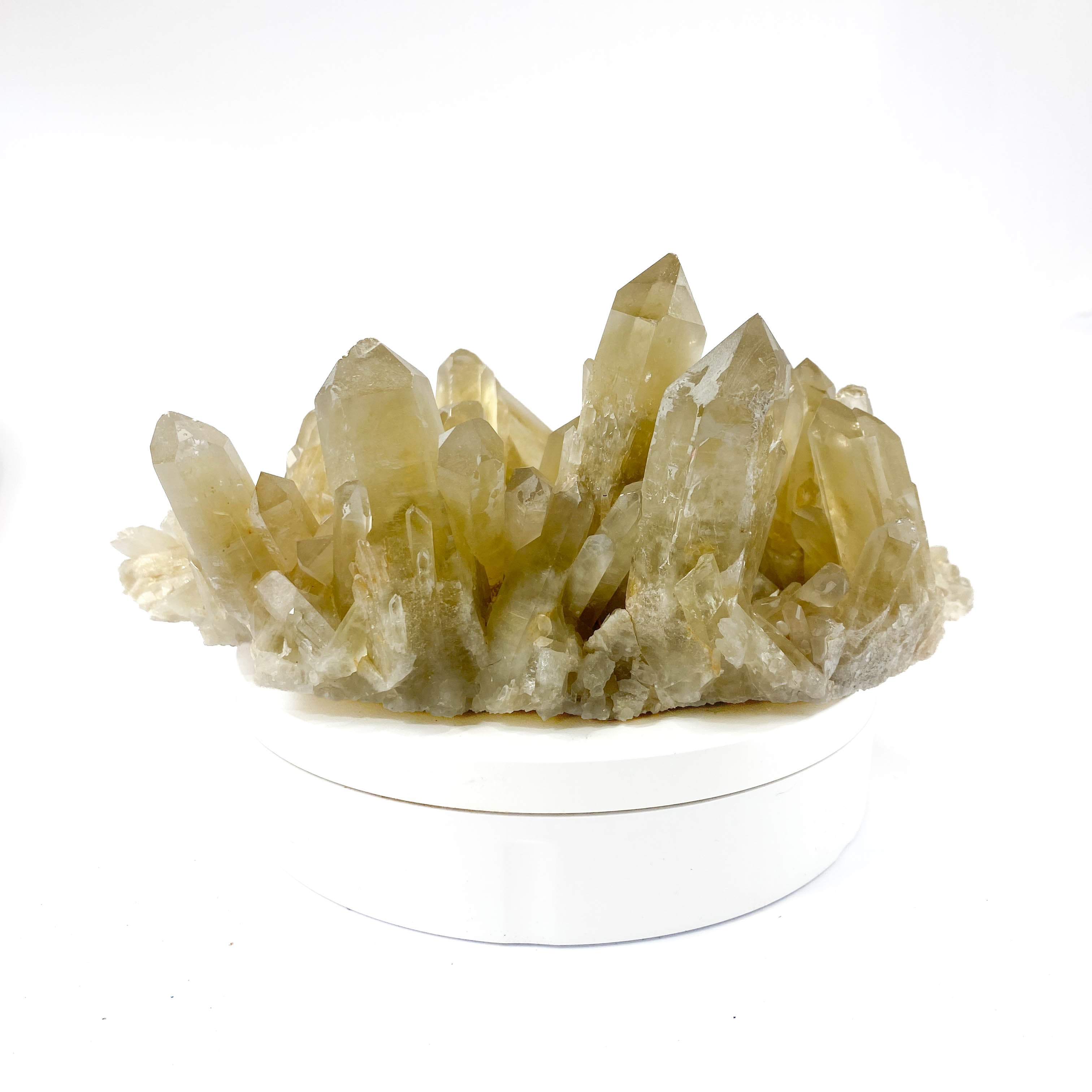 Natural citrine quartz cluster with clear crystal points on white background