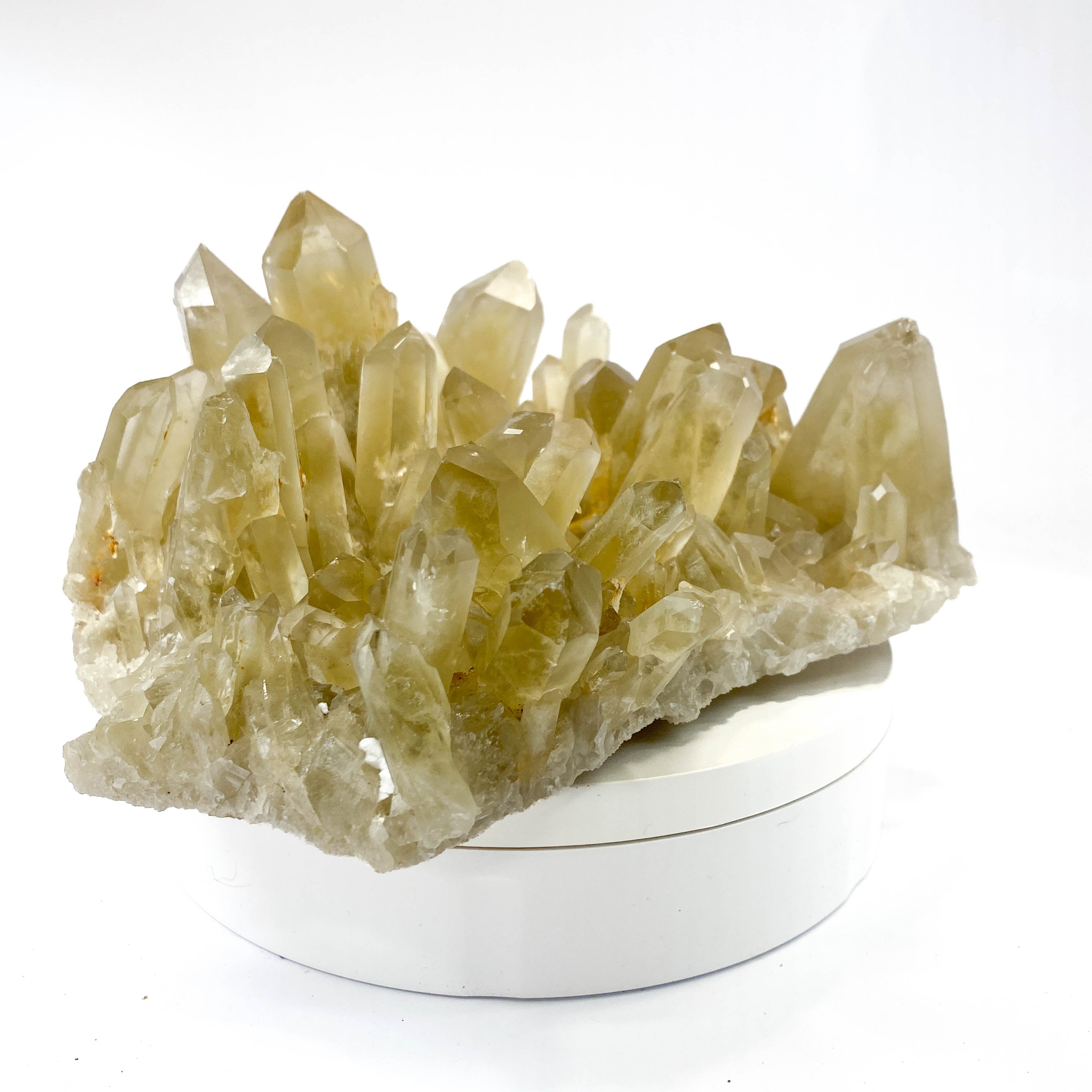 Natural citrine quartz cluster with clear crystal points on white background