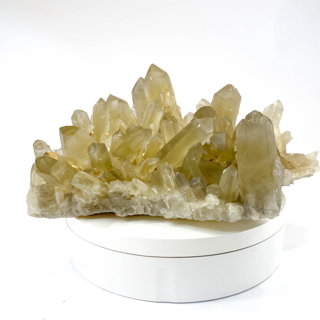 Natural citrine quartz cluster with clear crystal points on white background