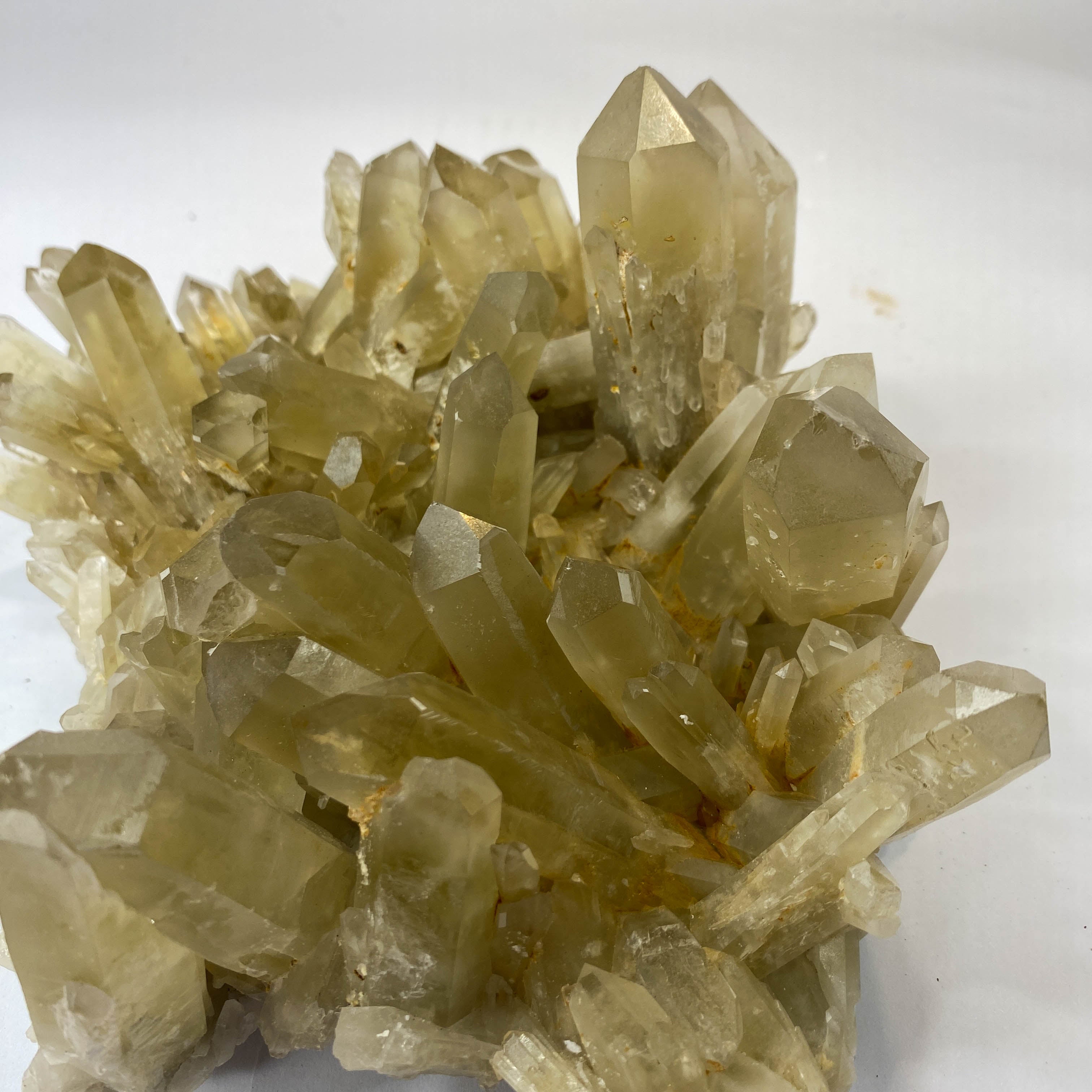 Natural citrine quartz cluster with clear crystal points on white background