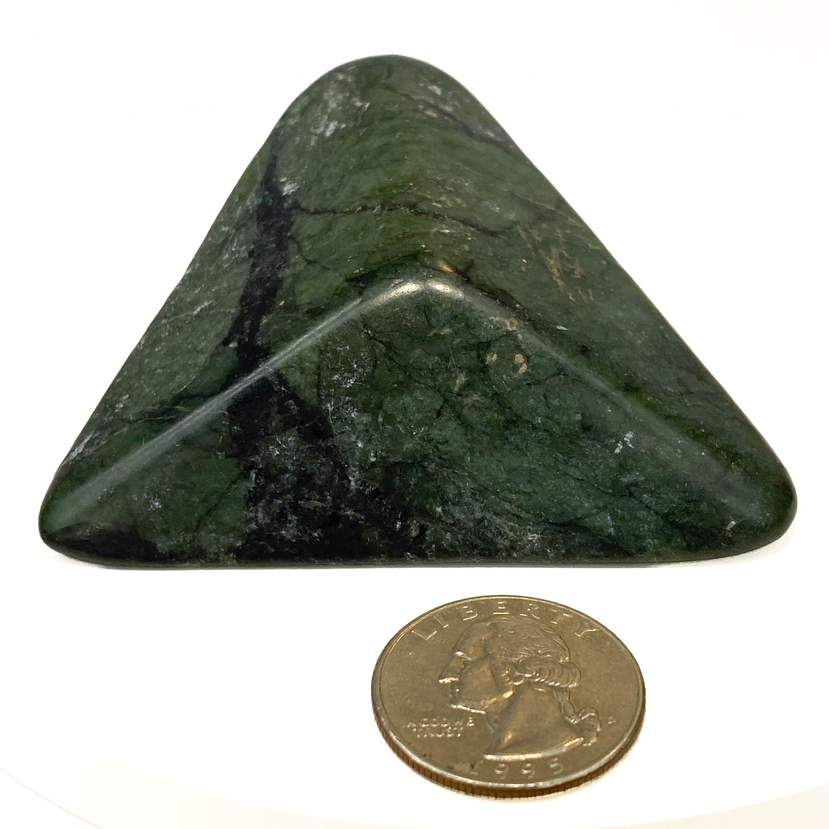 Carved Washington jade triangle with tree pattern on white background