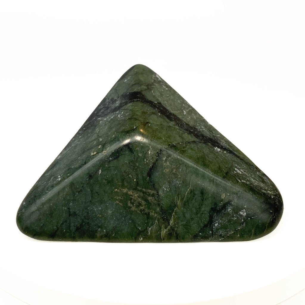 Carved Washington jade triangle with tree pattern on white background