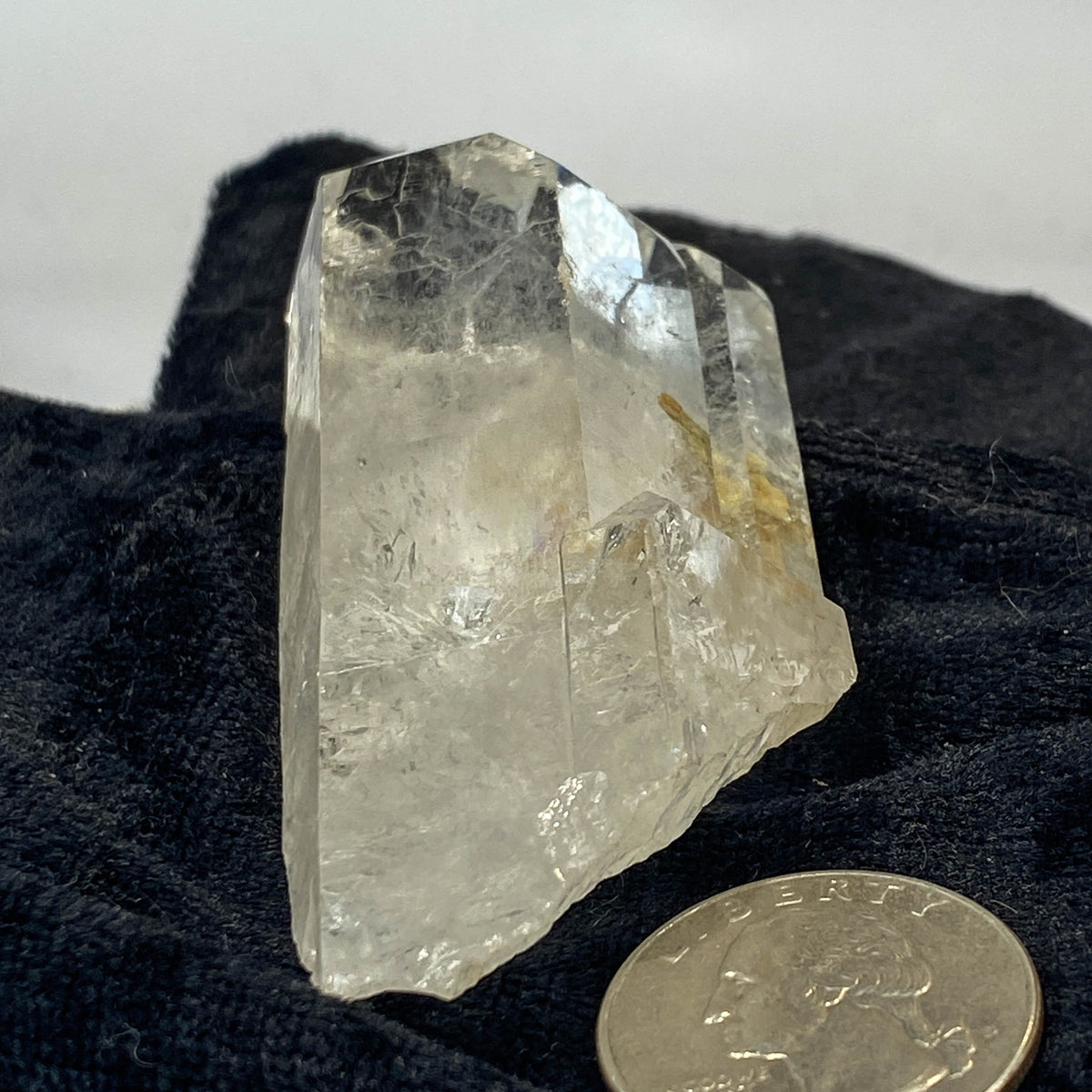 Tantric twin quartz crystal with rainbow refractions on black cloth background