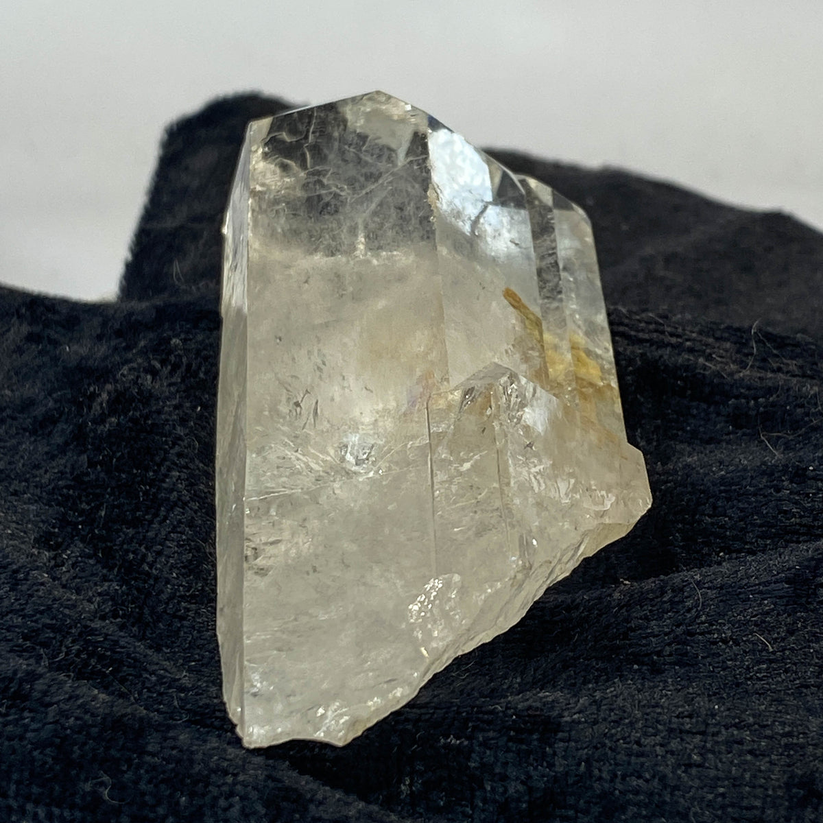 Tantric twin quartz crystal with rainbow refractions on black cloth background