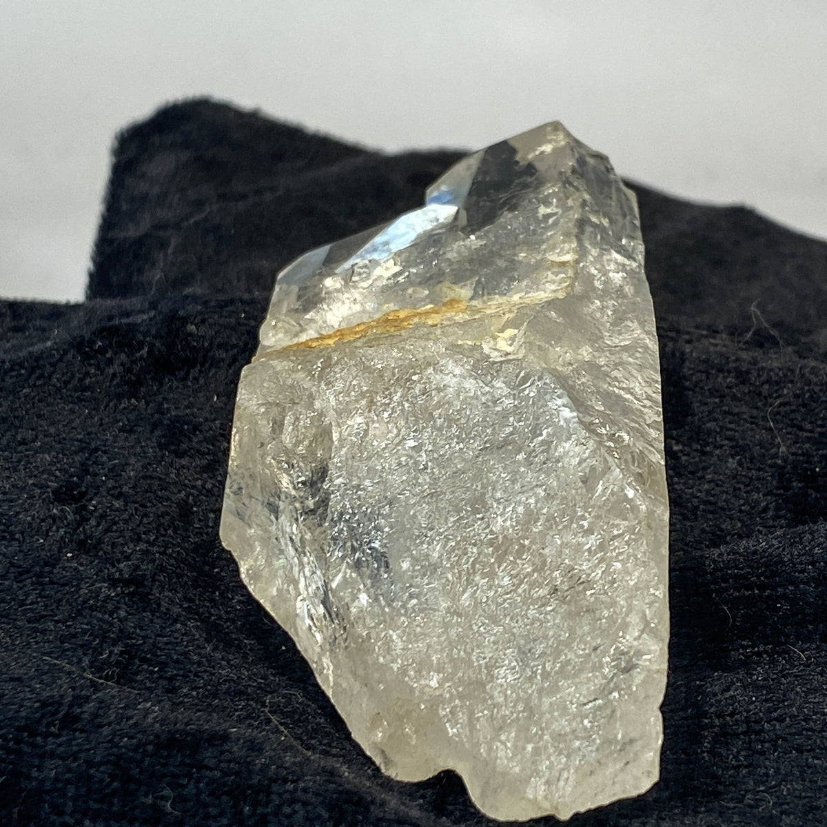 Tantric twin quartz crystal with rainbow refractions on black cloth background