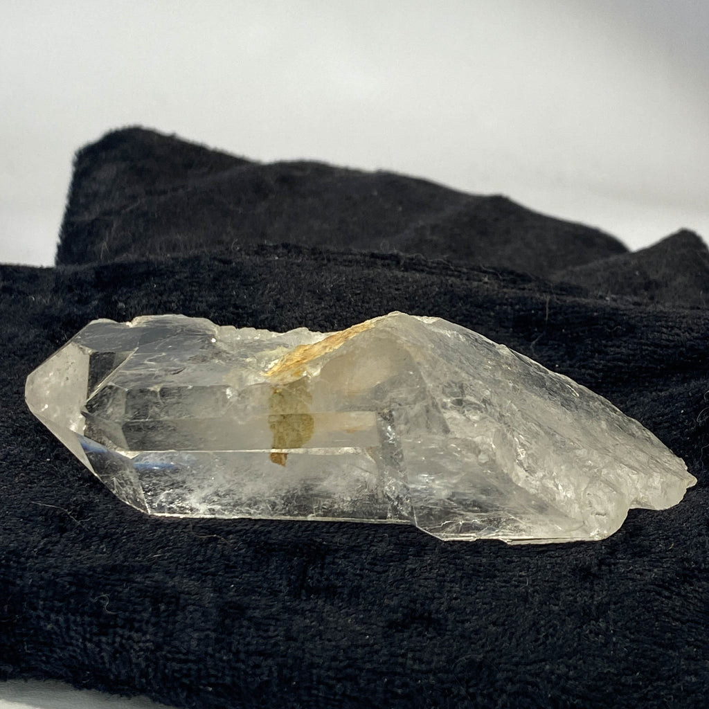 Tantric twin quartz crystal with rainbow refractions on black cloth background