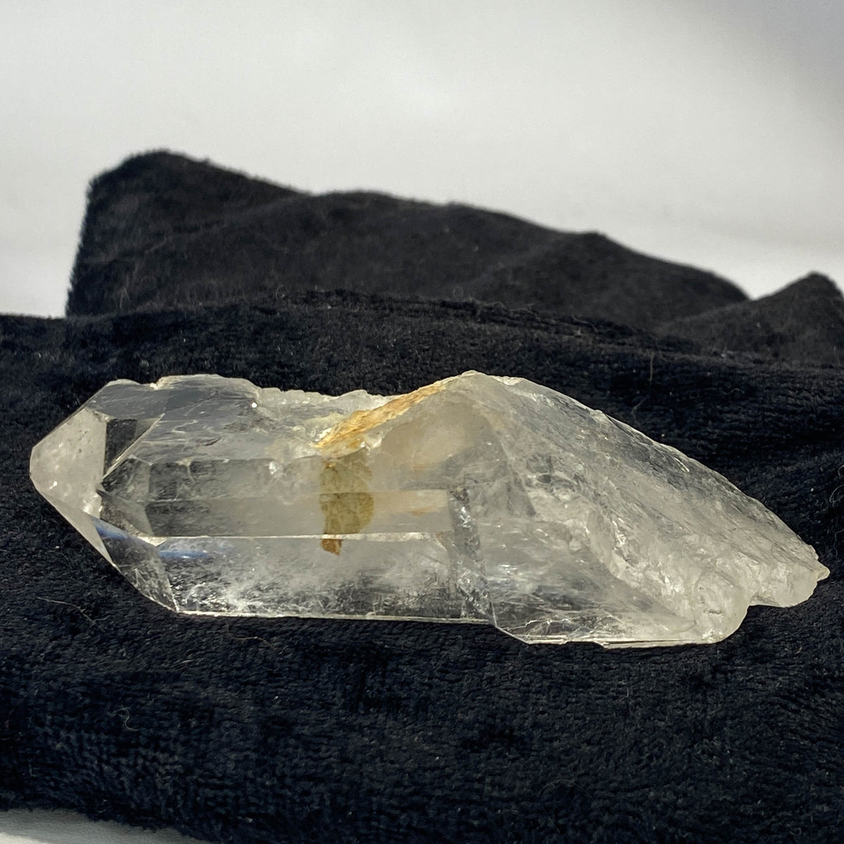 Tantric twin quartz crystal with rainbow refractions on black cloth background