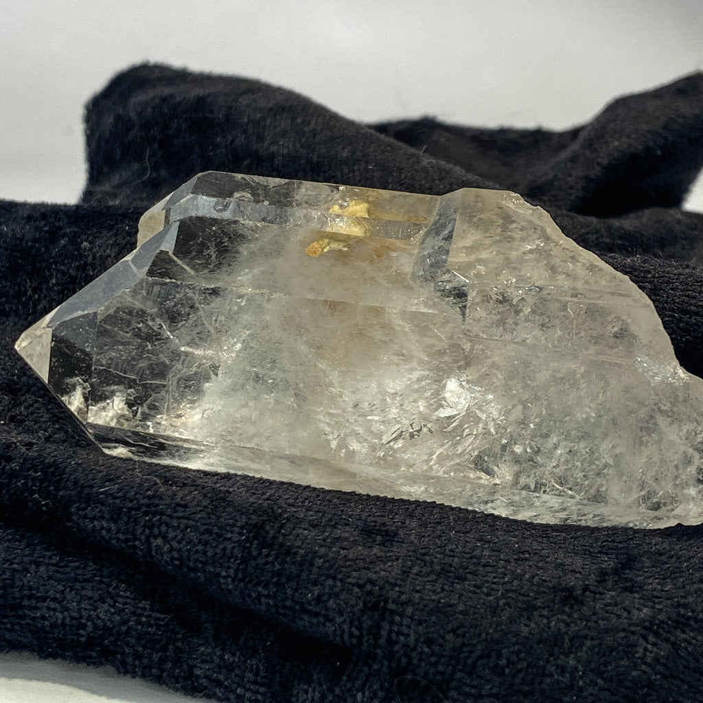 Tantric twin quartz crystal with rainbow refractions on black cloth background