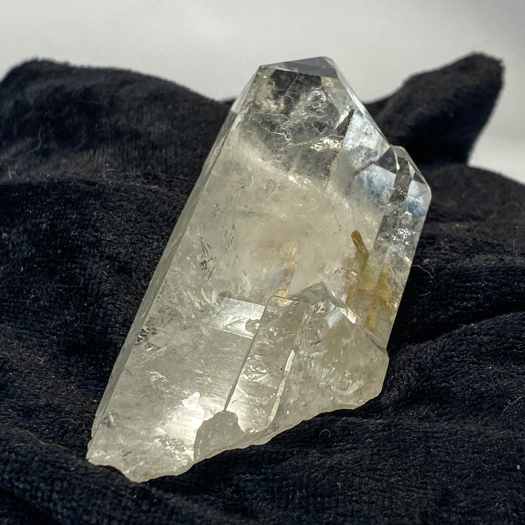 Tantric twin quartz crystal with rainbow refractions on black cloth background