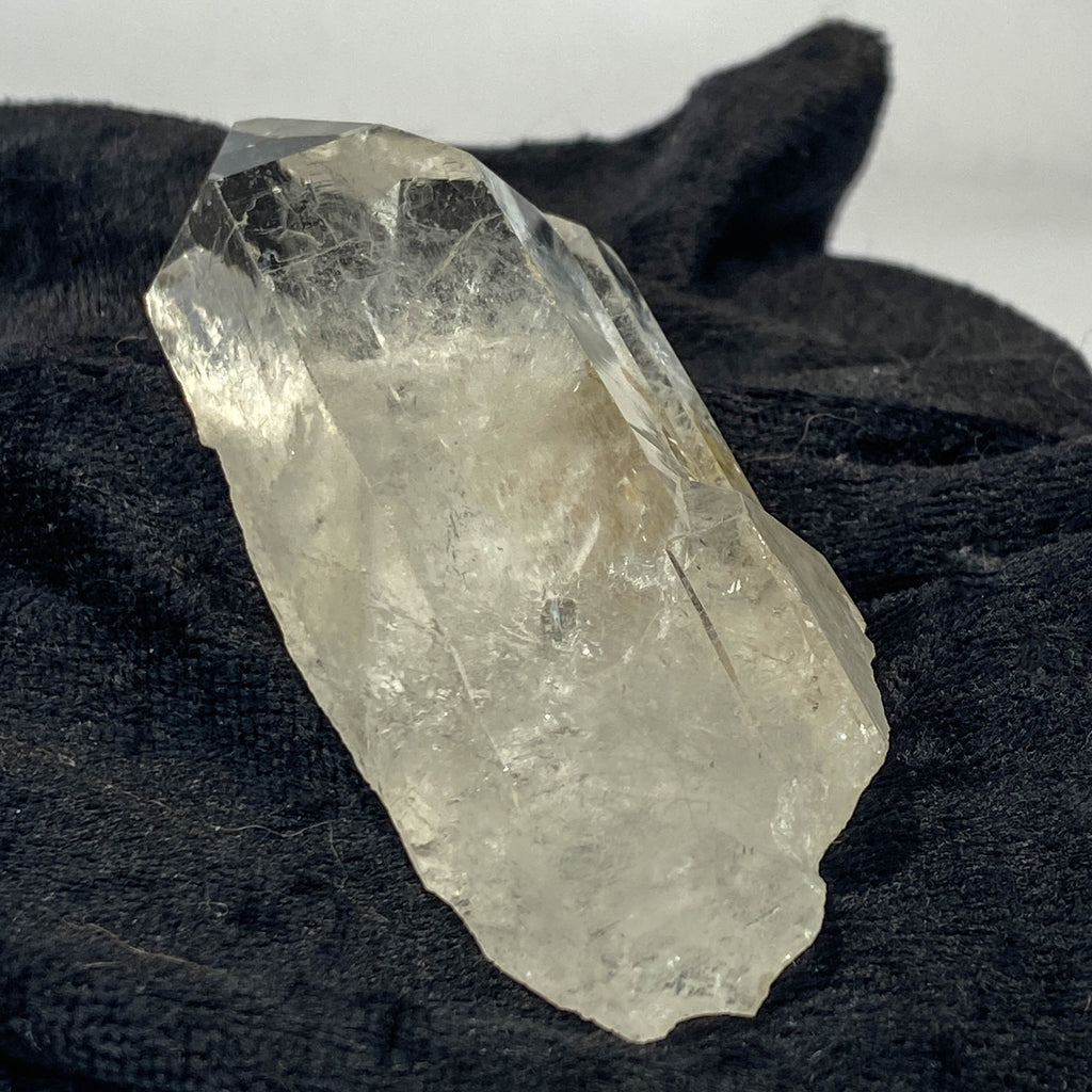 Tantric twin quartz crystal with rainbow refractions on black cloth background