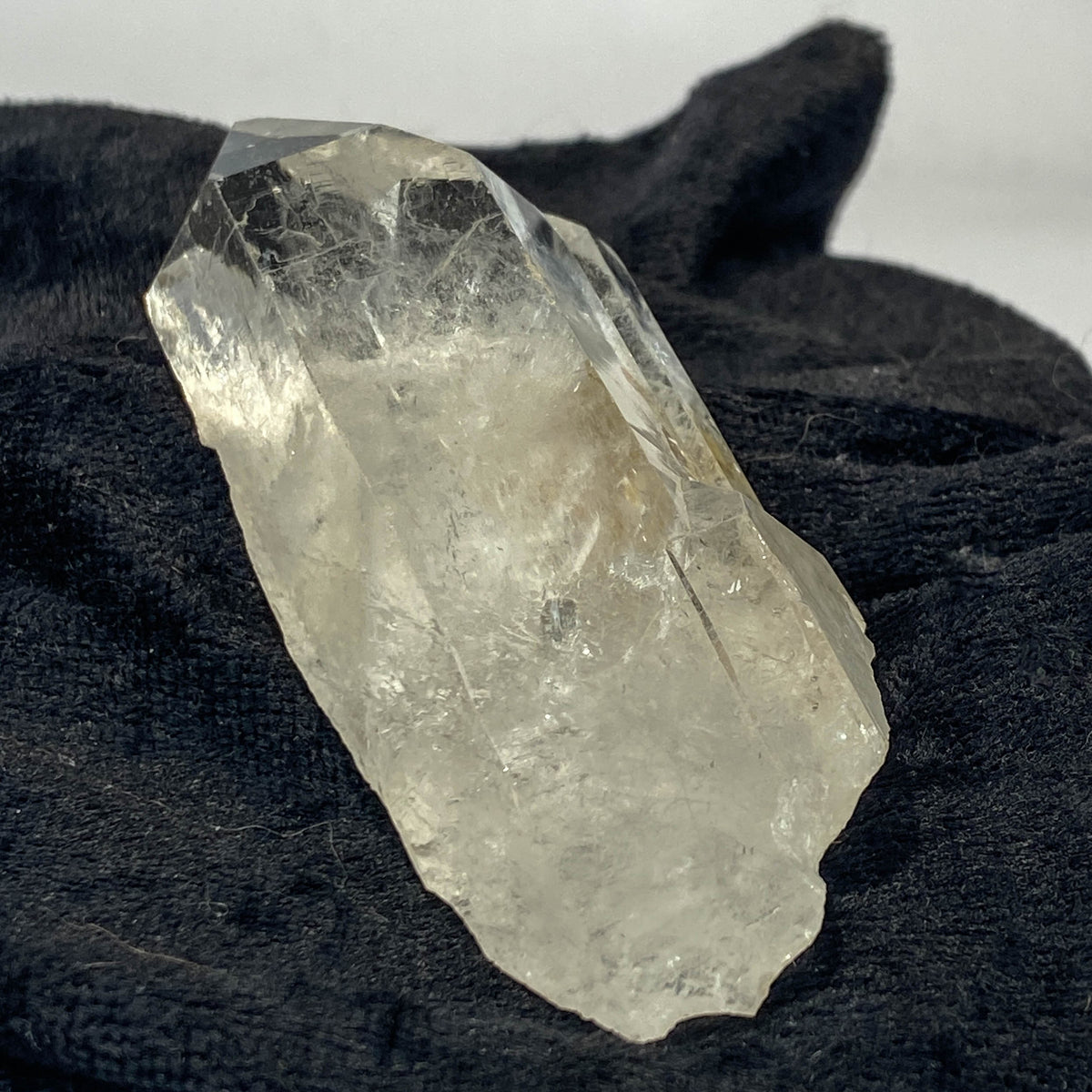 Tantric twin quartz crystal with rainbow refractions on black cloth background