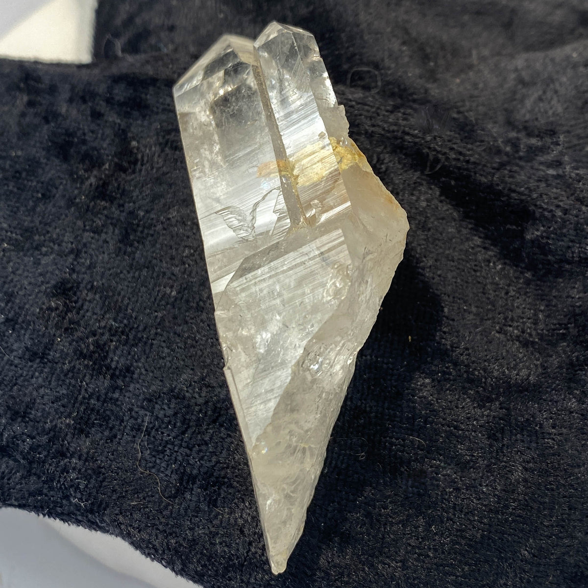 Tantric twin quartz crystal with rainbow refractions on black cloth background