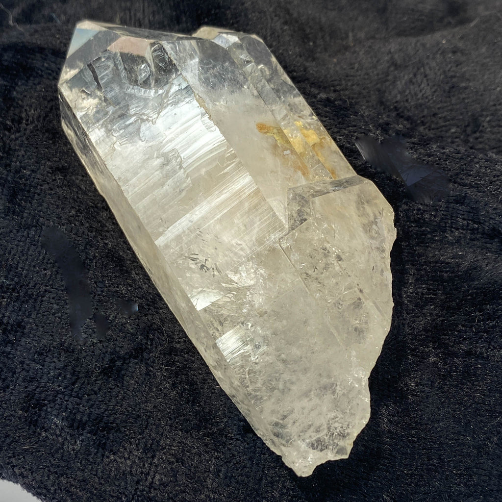 Tantric twin quartz crystal with rainbow refractions on black cloth background