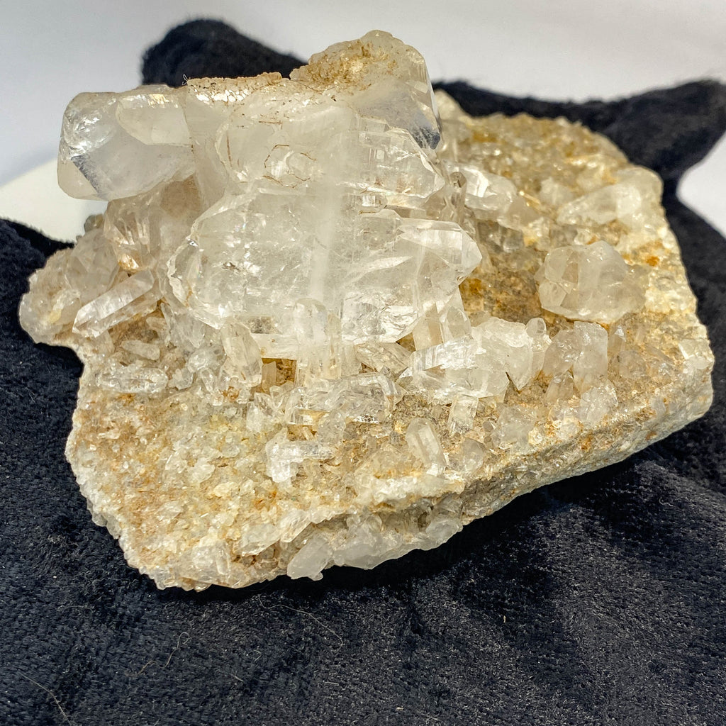 Double-sided quartz plate with clear crystal cluster on dark cloth background