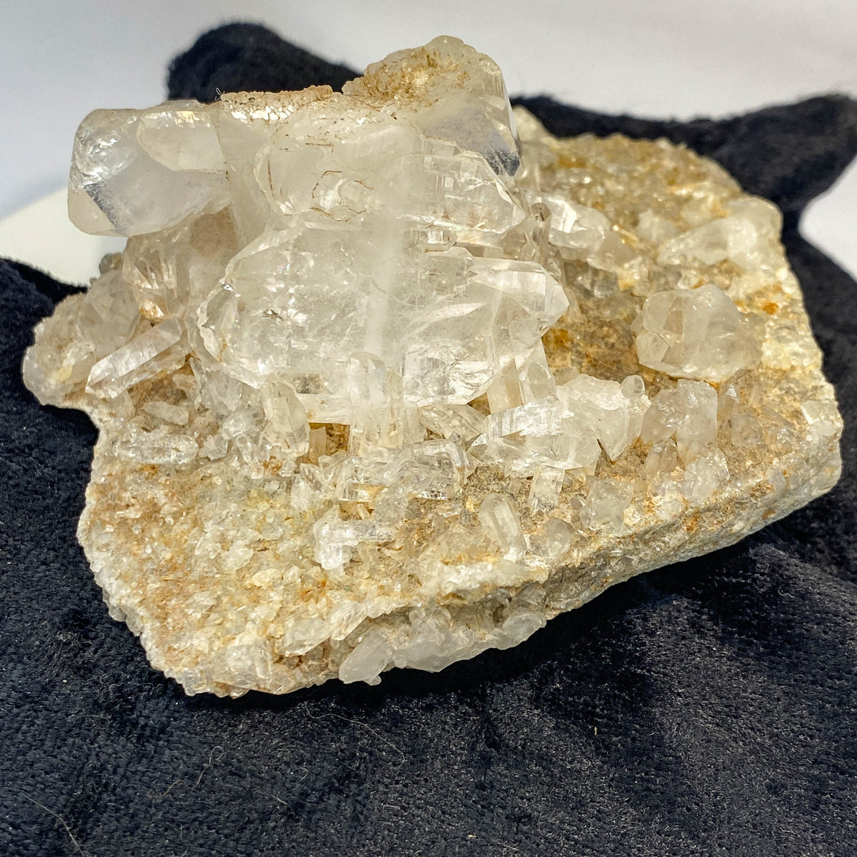 Double-sided quartz plate with clear crystal cluster on dark cloth background
