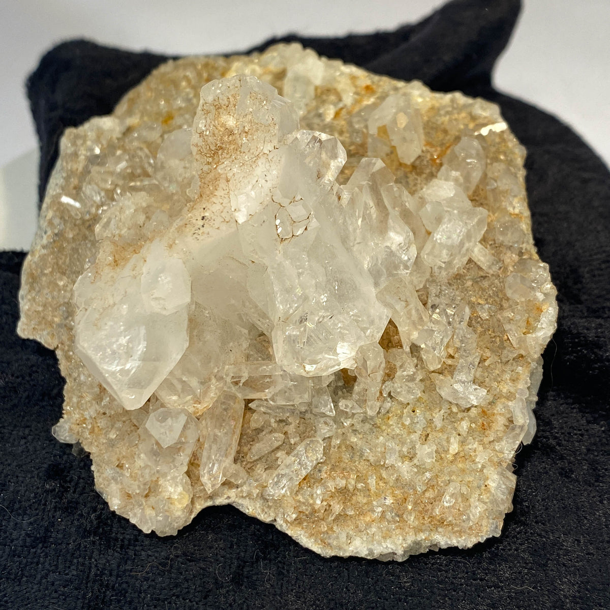 Double-sided quartz plate with clear crystal cluster on dark cloth background