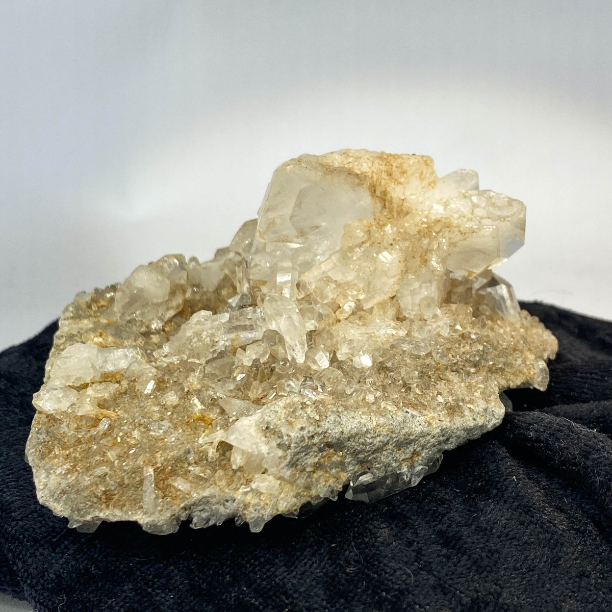 Double-sided quartz plate with clear crystal cluster on dark cloth background