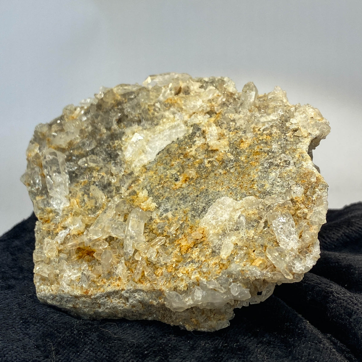 Double-sided quartz plate with clear crystal cluster on dark cloth background