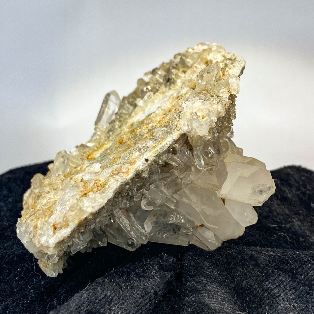 Double-sided quartz plate with clear crystal cluster on dark cloth background