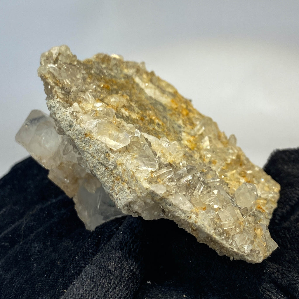 Double-sided quartz plate with clear crystal cluster on dark cloth background
