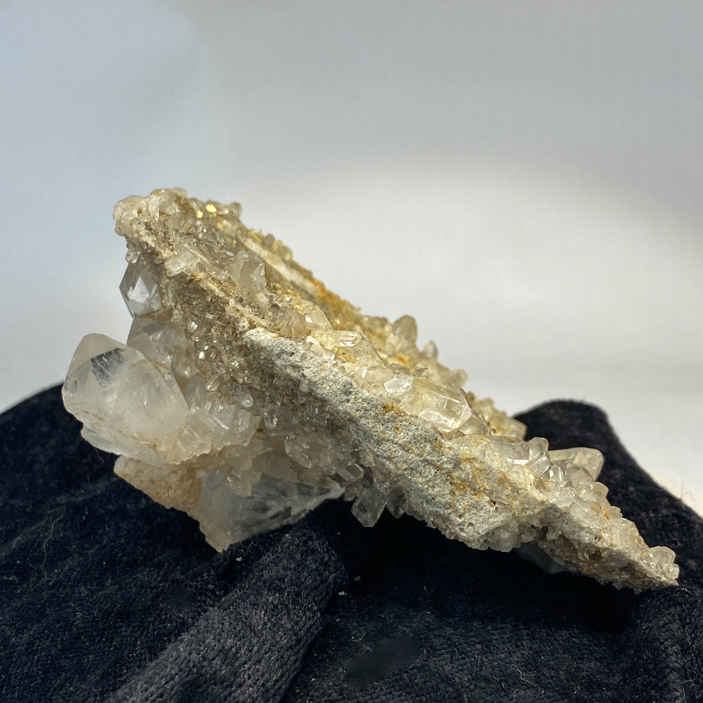 Double-sided quartz plate with clear crystal cluster on dark cloth background